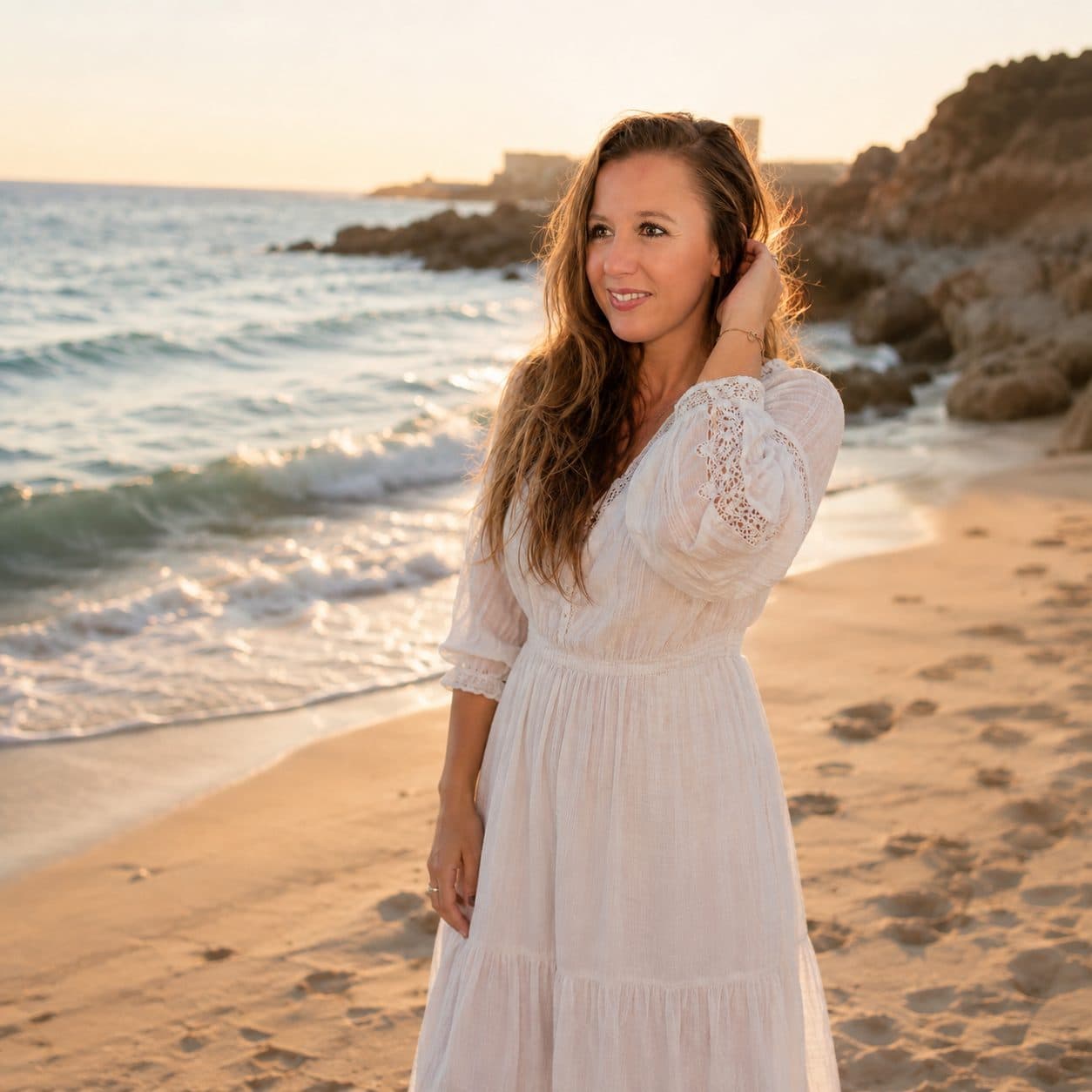 Marina Luque sonriendo en la playa, con vestido blanco